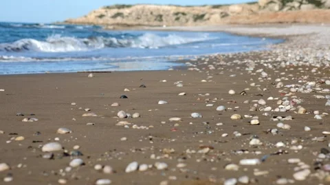 Wide sand beach and rolling sea waves with white thick foamy crests under blue Stock Footage 153840877