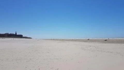 Wide Sandy Beach with Distant Lighthouse Stock Photos