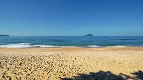 Wide Sandy Beach with Footprints, Ocean Waves and Distant Islands Stock Footage 343435428