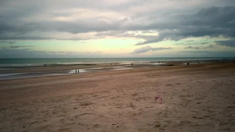 Wide Sandy Beach with People Strolling at Low Tide Stock Footage 284430580