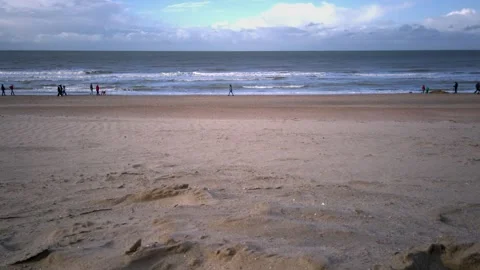 Wide Sandy Beach with People Strolling at Low Tide Stock Footage 284431859