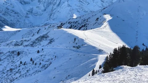 Wide scenic view of a snow-covered ski slope winding through the mountains near Stock Footage 346687170