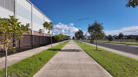 A wide, shared pedestrian sidewalk and bike path in suburban Australia Stock Footage 312087427