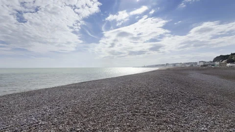 Wide shingle beach with distant town 4K Stock Footage 338135122