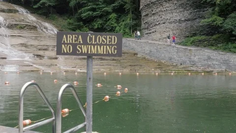 Wide Shot of an Area Closed No Swimming Sign by a Natural Swimming Spot Stock Footage 81692064