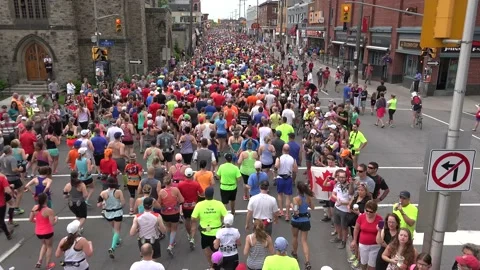 Wide shot of the backs of runners in a marathon Stock Footage 139977345
