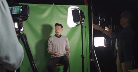 Wide shot behind the scenes of young Asian American man speaking to camera Stock Footage 277954092