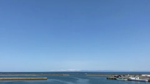 Wide Shot of a Big Blue Cloudless Sky and Ocean at Hokkaido's Dock Stock Footage 139342543