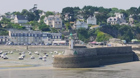 Wide shot of Binic port, showing a stone pier with a green-topped lighthouse Stock Footage 346678229