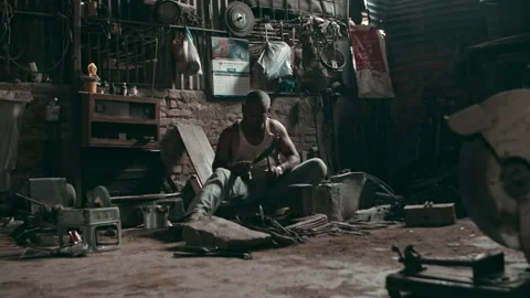 Wide shot of a blacksmith working in an old rural smithy workshop Stock Footage 142789273