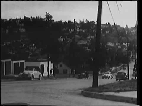 Wide shot of car pulling up alongside taxi, 1940s 스톡 동영상 58858746