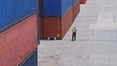 Wide shot of cargo container worker hold laptop and walk around to check Stock Footage 132313317
