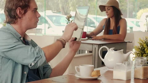Wide shot of casually dressed man thinking while using touch screen tablet compu Stock Footage 199635037