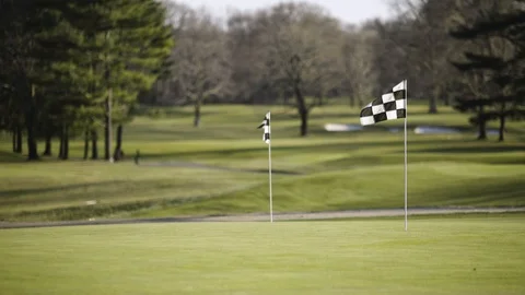 Wide shot of Checkerd flags on golf course PGA in 4k Stock Footage 106179369