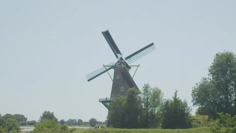 Wide shot of classical Dutch windmill with spinning sails. Tourists are 動画素材 157428298
