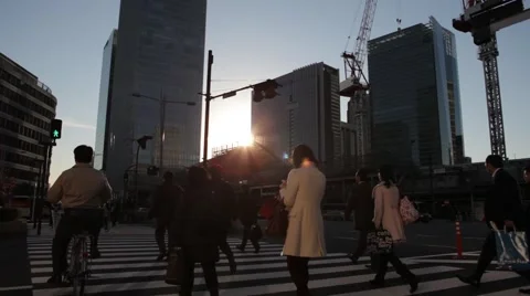 WIDE SHOT OF COMMUTERS CROSSING INTERSECTION SUNSET DURING RUSH HOUR IN TOKYO Stock Footage 59921611