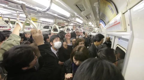 WIDE SHOT OF COMMUTERS IN CROWDED TRAIN DURING RUSH HOURS IN TOKYO Stock-Footage 59921368