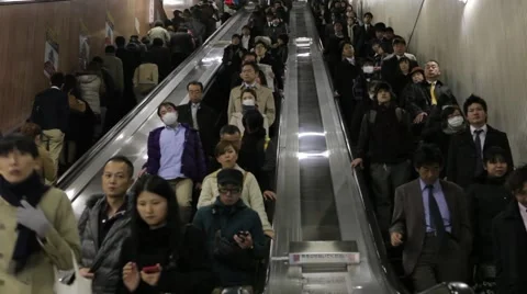 WIDE SHOT OF COMMUTERS ON ESCALATOR AT TRAIN STATION RUSH HOURS IN TOKYO Video stock 59921346