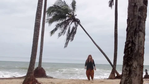 Wide shot of dancer on a beach with palm tree in background Stock-Footage 72794636