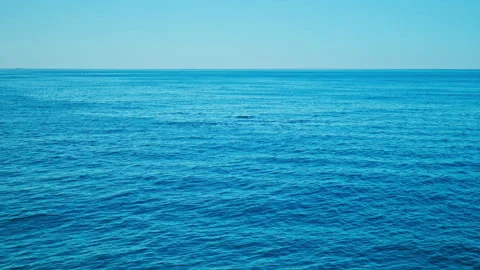 Wide shot of deep blue ocean with distant snow-covered mountains, in Iceland. Stock Footage 293635307