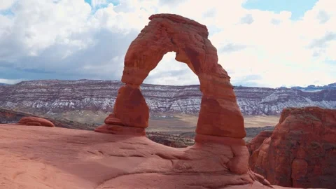 Wide shot of Delicate Arche at the top of the mountains in arches national park Stock Footage 293483941