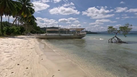 Wide shot of deserted beach with rusty boat on Palawan island morning Stock Footage 339977439