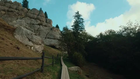 Wide shot of dramatic rock formations and a mountain hut against a blue sky Stock Footage 321273815