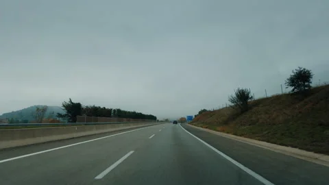 Wide shot driving on empty highway road on cloudy autumn day Stock Footage 256772773