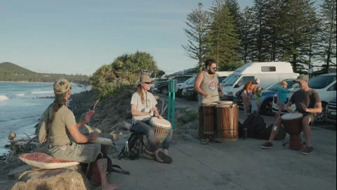 Wide shot of a drum ensemble playing african drums at byron bay Stock Footage 165539354