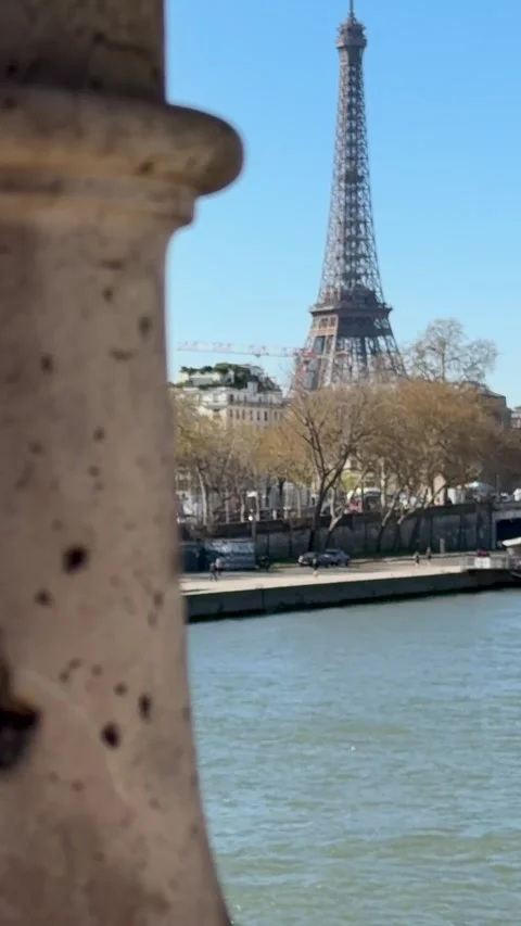 Wide shot of Eiffel Tower over Seine with moving boat and clear sky Stock Footage 346665124