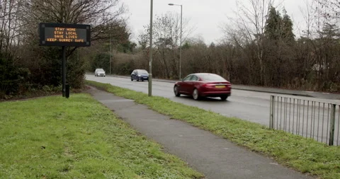 Wide shot of electronic display by busy road to stay safe Stock Footage 146465986