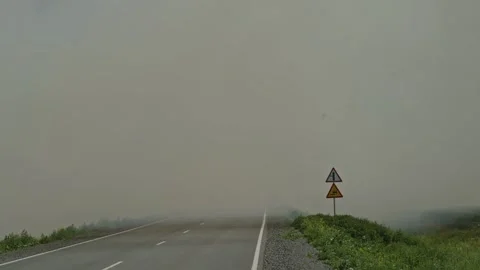 Wide shot of empty asphalt road covered in dense toxic smoke Stock Footage 337391454