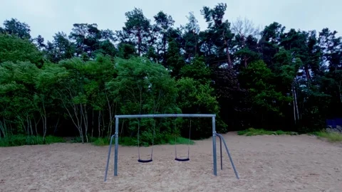 Wide shot of empty swing set on sandy beach near coastal pine woods in Jurmala Video stock 344355987