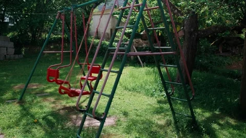 Wide Shot Empty Swing Swaying in Garden Stock Footage 335142314