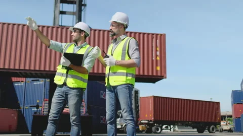 Wide shot of engineer man or cargo container workers stand and discuss Stock-Footage 146476195