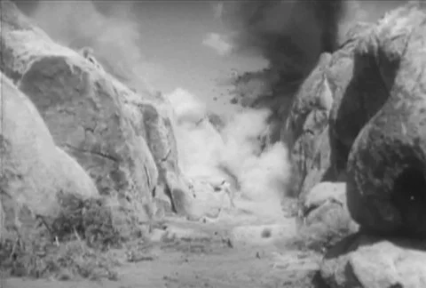 Wide shot of explosion between rocks in canyon, 1930s Stock Footage 95997408