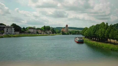 Wide shot facing Yonne River with boat and trees on right, Sens, France 스톡 동영상 339201312