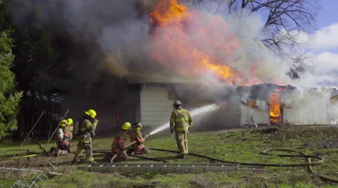 Wide shot of firemen hosing down burning house Video stock 60985840