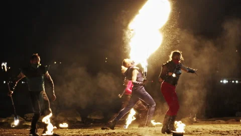 Wide shot of five powerful fire artists of mixed-gender performing together. Stock Footage 144749756