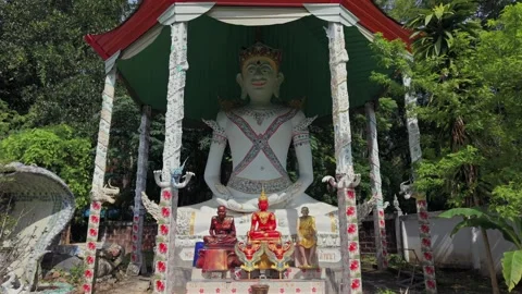 Wide shot of a giant deity statue and three smaller Buddha figures Stock Footage 335618013