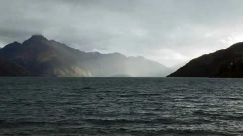 Wide shot god rays shining on hills and lake, New Zealand Stock Footage 89811786