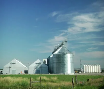 Wide shot of grain elevators green grass and blue sky Stock Footage 21591867