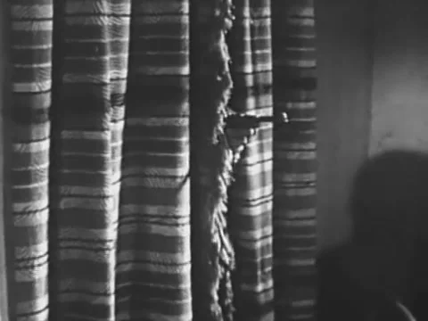 Wide shot of hand emerging from behind curtain and shooting gun, 1940s Stock Footage 65860480