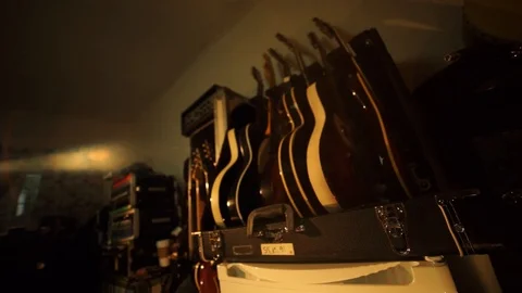 A wide shot from a hand held camera holding on a row of guitars in a Stock Footage 102828251