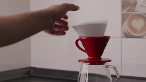 Wide shot of hands placing filter into V60 coffee dripper Stock Footage 332720244