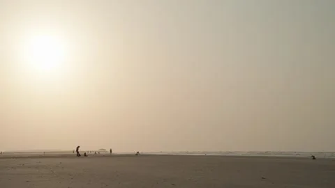 Wide Shot of Hazy Beach at Sunset with Silhouetted People in São Luís 库存影片 334699445