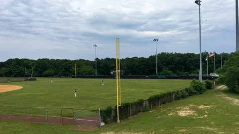Wide shot of high school  baseball field.
Camer pan from outfield to home Stock Footage 104412029