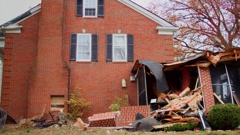 Wide shot of a home with significant structural damage to the exterior after a Stock Footage 303653205