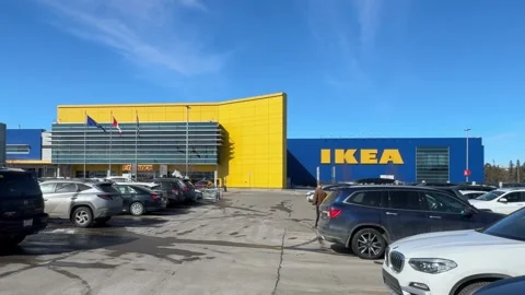 Wide shot of an IKEA storefront and parking lot under a clear blue sky Stock-Footage 332518542
