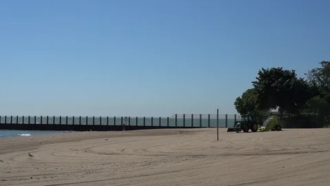 WIDE SHOT OF LARGE BEACH RAKE TRACTOR Stock Footage 106125481